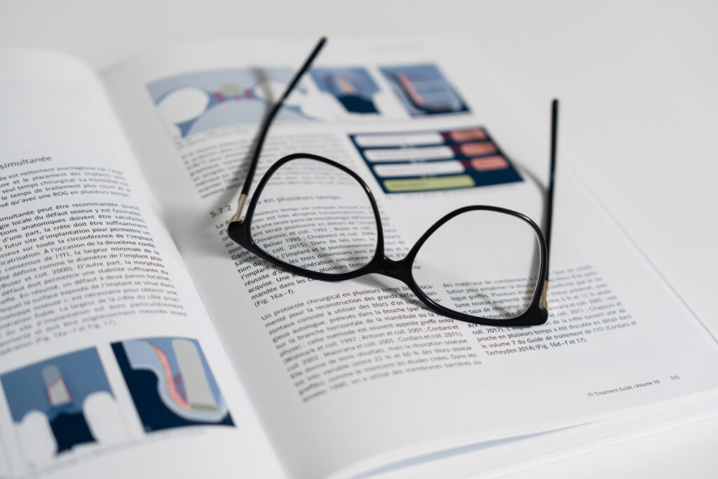 Livre médical ouvert avec illustrations dentaires et lunettes