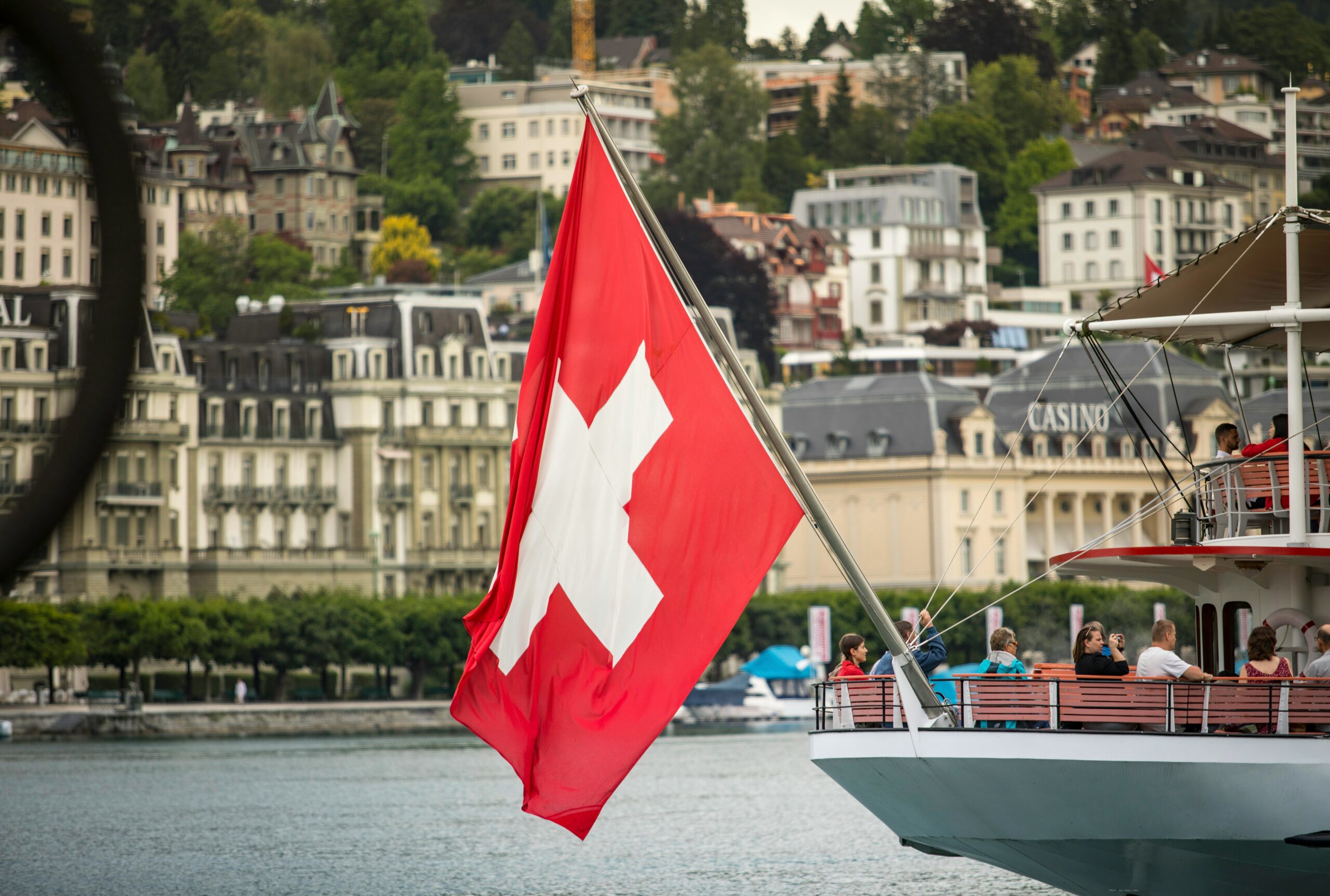 Drapeau suisse devant un paysage urbain, symbole du savoir-faire suisse