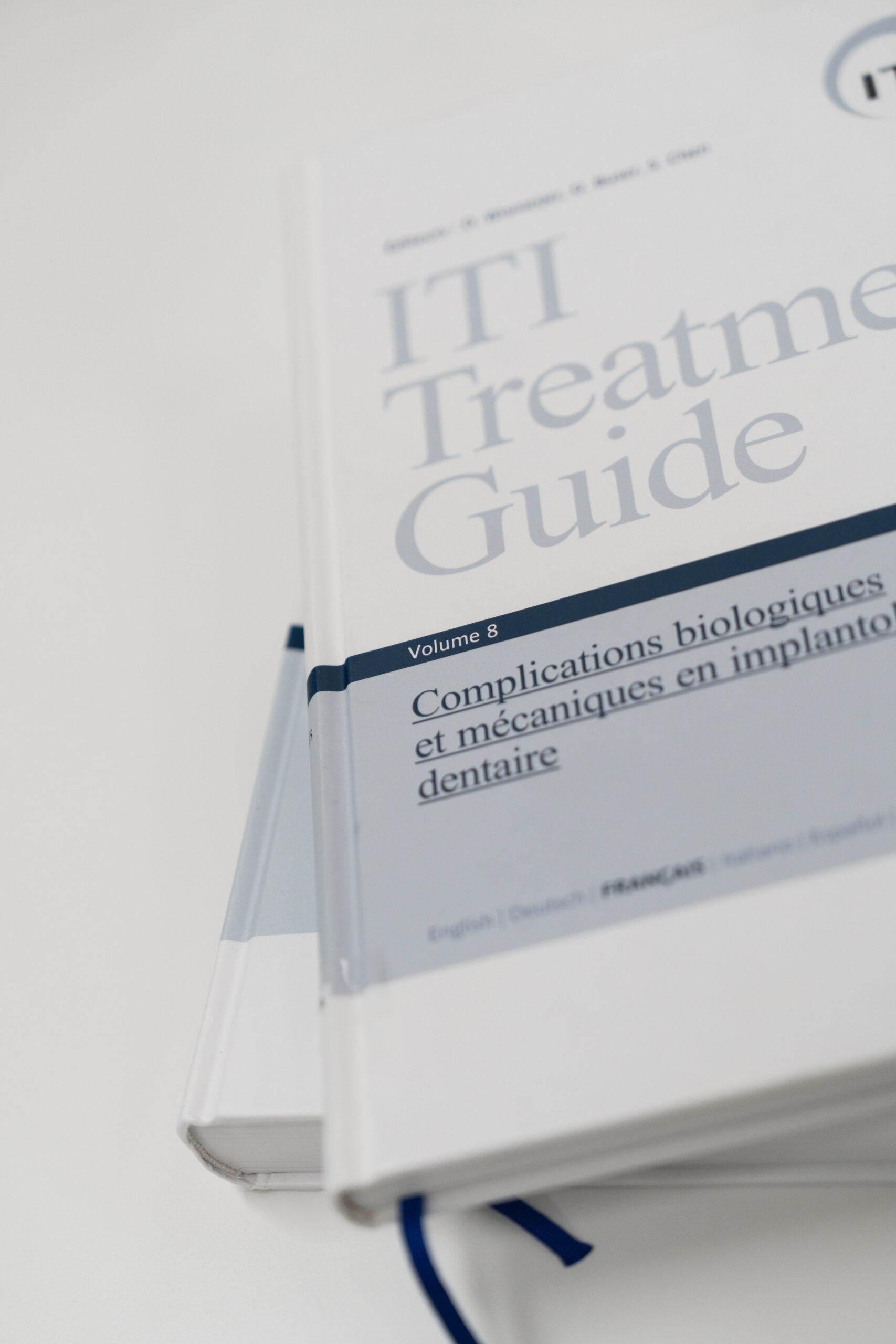 Close-up of the ITI Treatment Guide book focusing on dental complications and implant mechanics, highlighting dental health and implantology topics.