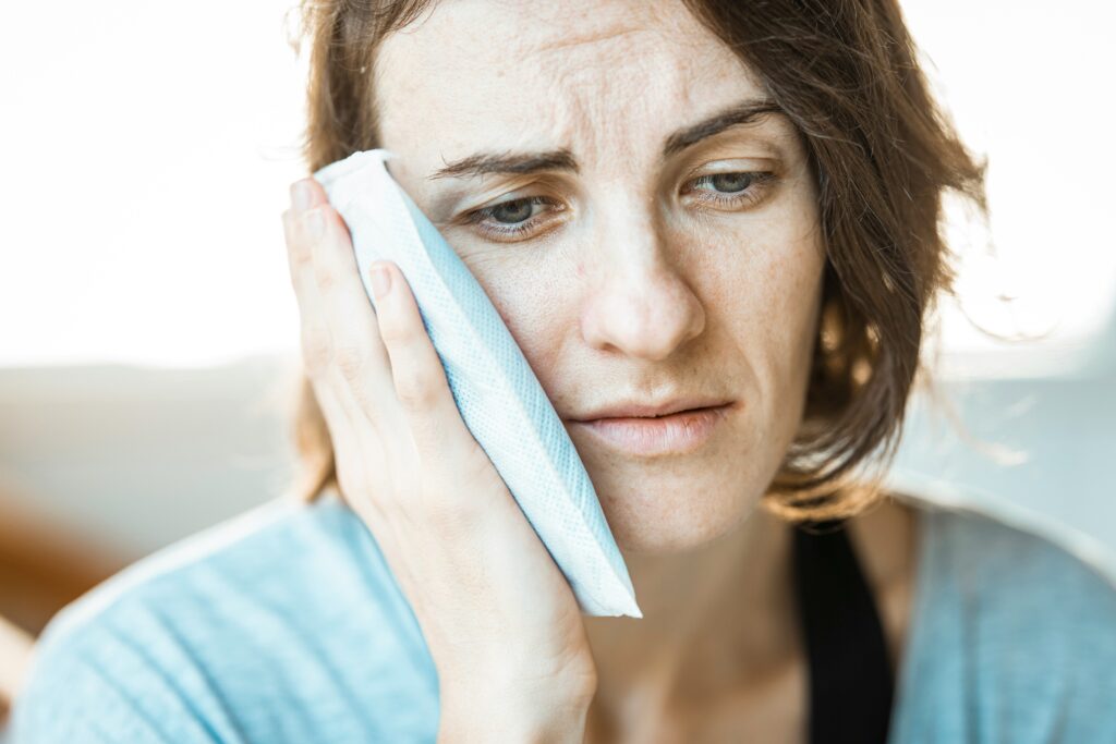 Femme ressentant une douleur à la mâchoire liée au bruxisme