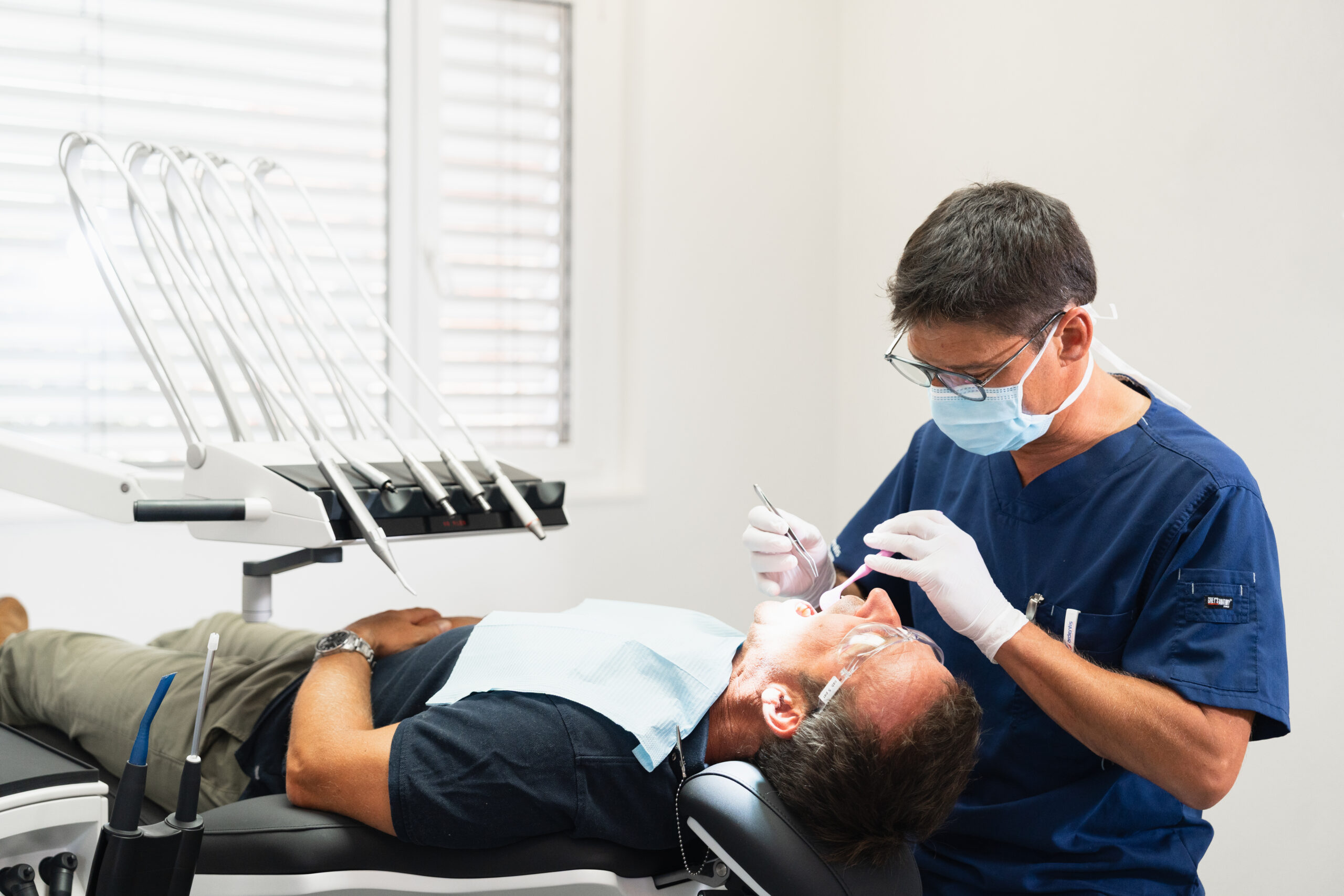 Dentiste effectuant un traitement dentaire sur un patient allongé